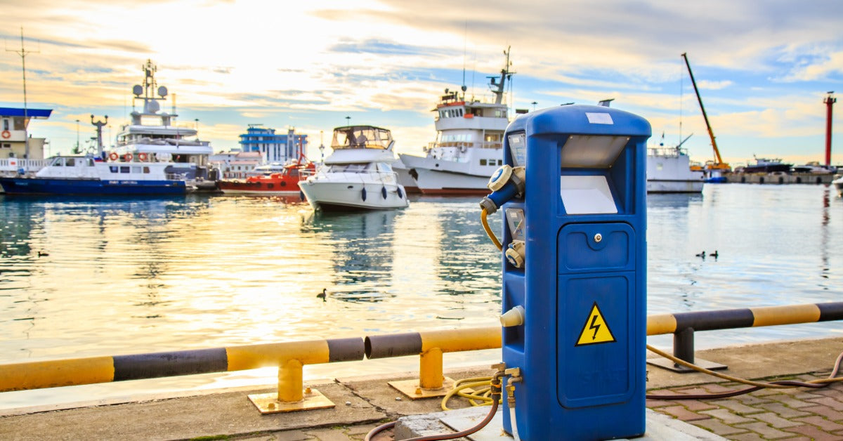 A charging station for boats in a docking area. The charging station has a warning symbol to indicate shock risk.