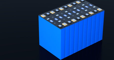 A series of blue lithium batteries sitting side-by-side in a tight stack against a plain black background.